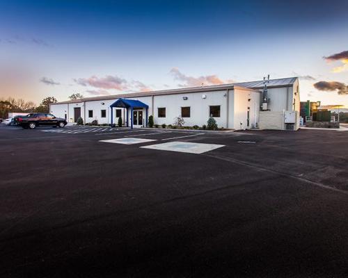 Exterior photo of the white facility with blue entry canopy